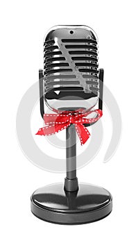 Retro microphone with red bow isolated on white. Christmas music