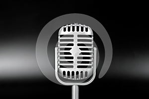 Retro microphone of silver on black background