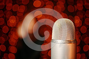 Retro microphone on stage with bokeh light background.