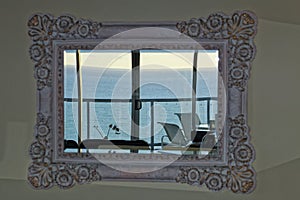Retro mirror in living room with view to ocean from top floor apartment