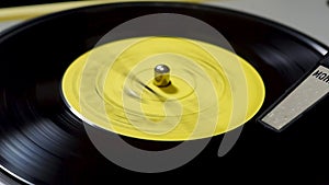 Retro musical vinyl record is playing on old turntable close up