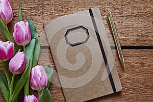 Retro notebook and golden pen with pink tulips