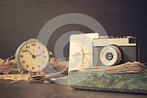 Retro old camera with pile of photos, letters, malachite box and antique watches on wooden background. Memories, nostalgia,