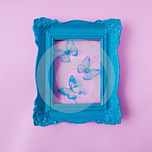 A retro old fashionned pastel blue frame with blue butterflies against pastel pink background. Romantic spring summer design for photo