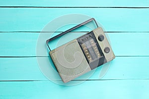 Retro old radio receiver on a blue wooden background. Top view. Outdated technology.