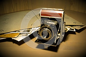 Retro old vintage outdated manual film camera circa 1940s and vintage photo album on wooden table