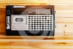 Retro oldschool design radio cassette tape recorder on wooden table.