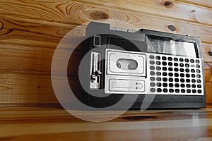 Retro oldschool design radio cassette tape recorder on wooden table.