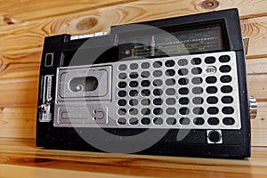 Retro oldschool design radio cassette tape recorder on wooden table.