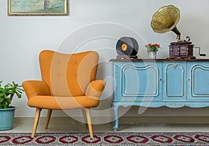 Retro orange armchair and vintage wooden light blue sideboard