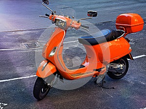 The retro orange classic scooter on street of city