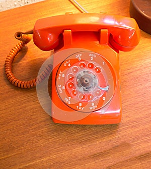 Retro orange rotary dial telephone.