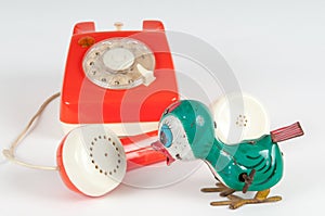 Retro orange telephone with rotary dial on white