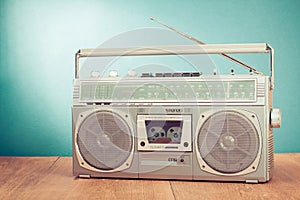 Retro outdated silver portable stereo radio cassette recorder from 80s front blue background. Vintage old style photo