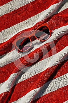 Retro pair of sunglasses on red and white striped beach towel