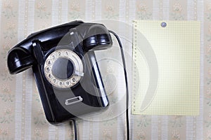 Retro phone and blank on a wooden wall