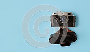 Retro photo camera on blue background, top view