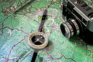 Retro photoapart and compass are on top of the tourist map. The concept of travel. Trails and routes are depicted on the map