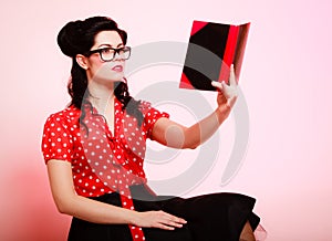 Retro. Pinup girl in eyeglasses reading book