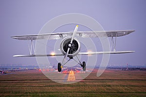 Retro plane fly up over takeoff runway from airport at twilight