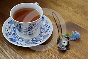 Retro pocket watch with forget me nots and cup of tea