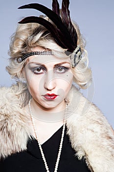 Retro portrait of a girl in a hat with feathers and lace gloves