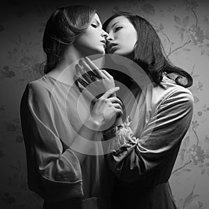 Retro portrait of two gorgeous women (girlfriends) kissing