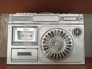 Retro radio and cassette stereo recorder on brown background. Old silver retro ghetto blaster.