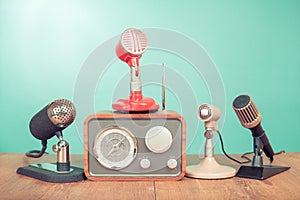 Retro radio, old microphones for press conference or interview on table front aquamarine background. Vintage old style filtered