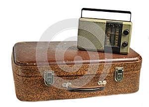 Retro radio receiver on old leather suitcase isolated on white background