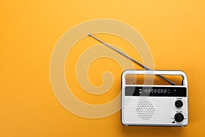 Retro radio receiver on orange background, top view. Space for text