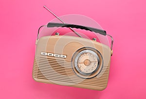 Retro radio receiver on pink background, top view