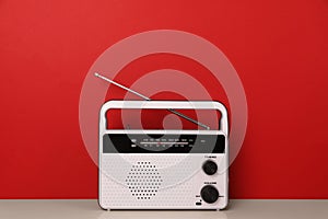 Retro radio receiver on table against red background