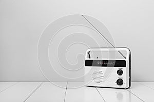 Retro radio receiver on white wooden table. Space for text