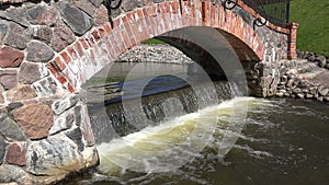Retro red brick and stone arch and waterfall water flowing. 4K