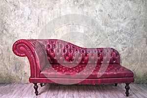 Retro red leather sofa with old wall background, copy space for text