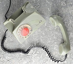 Retro rotary telephone on a gray concrete background. Top view