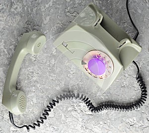 Retro rotary telephone on a gray concrete background. Top view