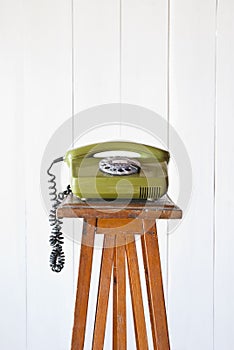 Retro rotary telephone on wood vintage table. White background