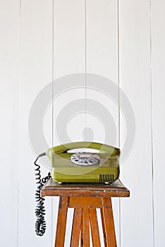 Retro rotary telephone on wood vintage table. White background