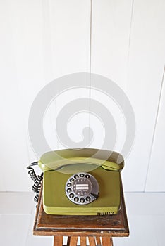 Retro rotary telephone on wood vintage table. White background