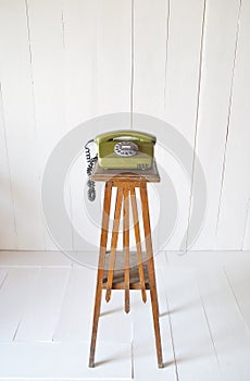 Retro rotary telephone on wood vintage table. White background