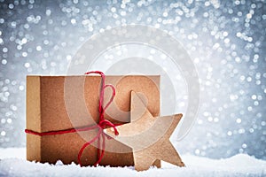 Retro rustic Christmas gift, present in snow on glitter background