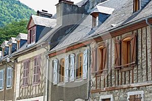 Retro rustic houses with old traditional windows and shutters downtown in picturesque french village in Arreau, France