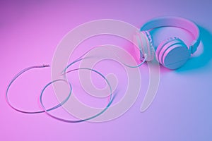 Retro 90s style photo of white stylish wireless headphone in neon lights. Music concept. photo