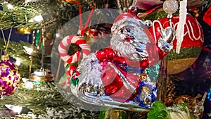 Retro Santa on sled waving ornament on old fashioned Christmas Tree close-up