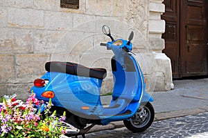 Retro scooter in old city Lviv. Retro film. Old blue moped on city street