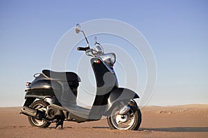 The Retro scooter at sunset in the golden sand of the Namib Desert