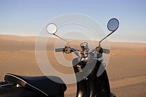 The Retro scooter at sunset in the golden sand of the Namib Desert