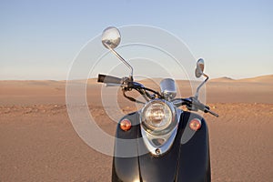 The Retro scooter at sunset in the golden sand of the Namib Desert